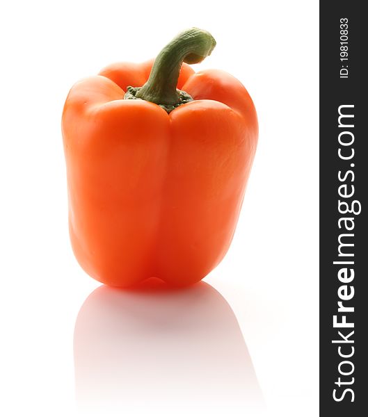 Orange pepper on white isolated background with a hint of reflection