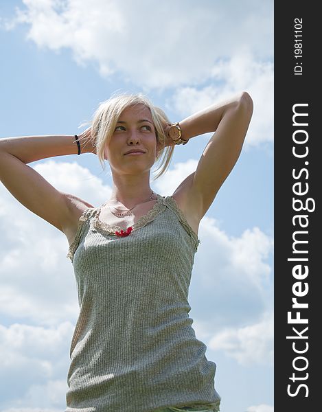 A young athletic girl against the sky