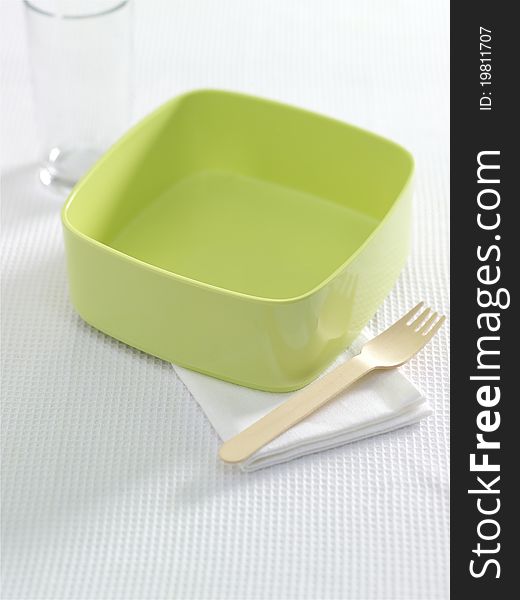 Green bowl with fork and napkin