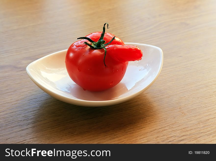 Red tomato on a white plate