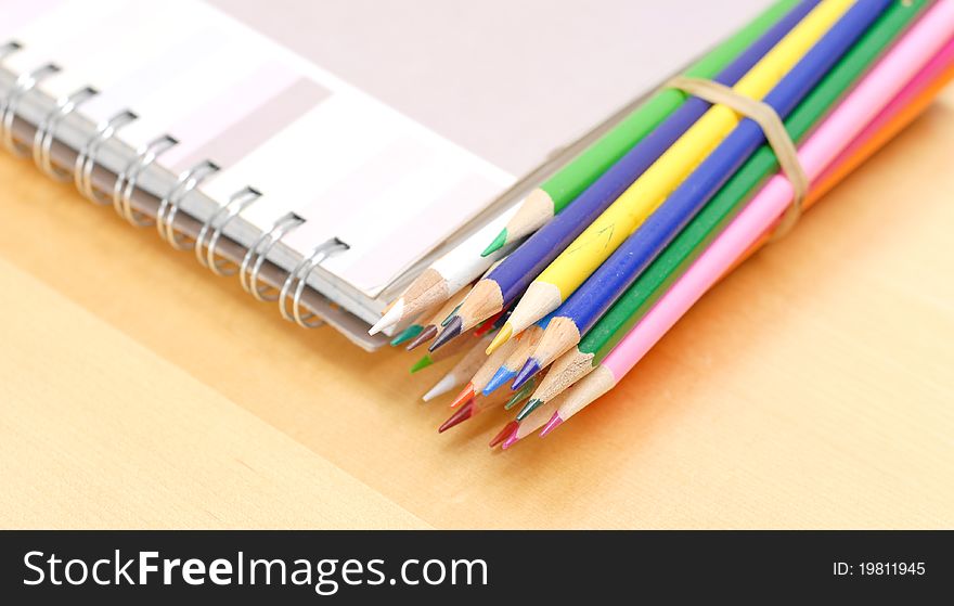 Colored Pencils with Art Book On Table