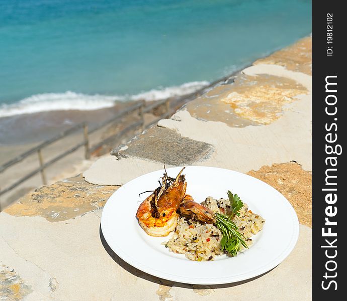 The dish with srimps and rice near mediterranean shore. Greece.