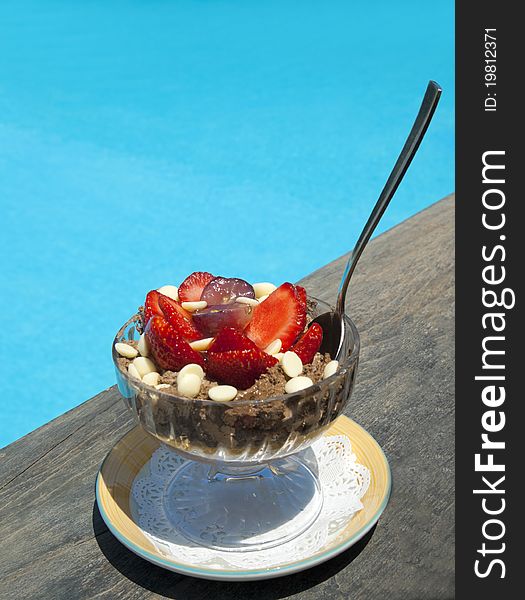 Delicious dessert with chocolate and strawberry near swimming pool