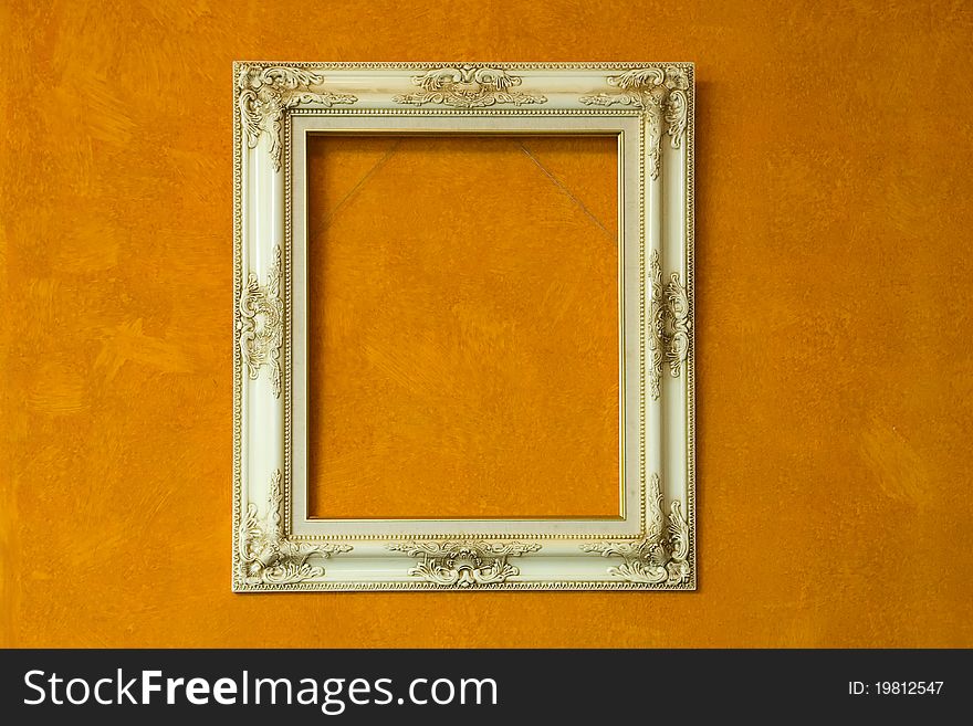 Blank antique ivory frame on orange painting background