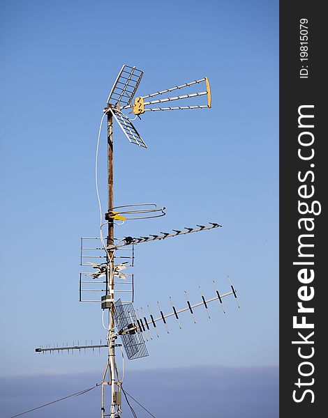 Multiple TV aerials against a blue sky