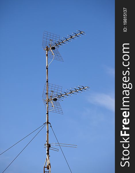 Two TV aerials against a blue sky