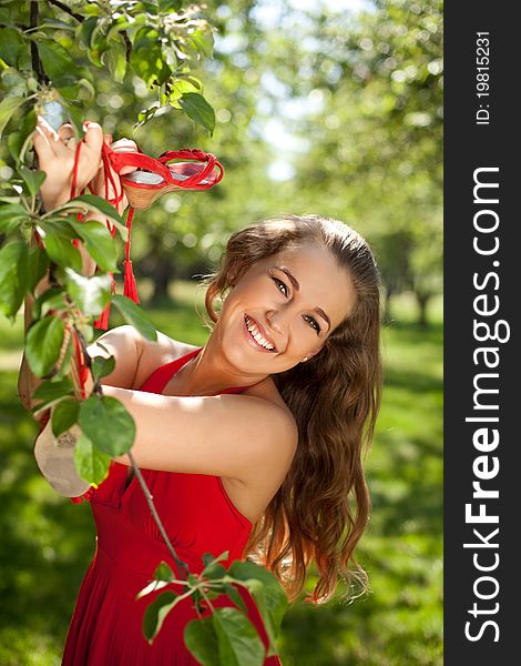 Beautiful girl in red dress in the sunny park
