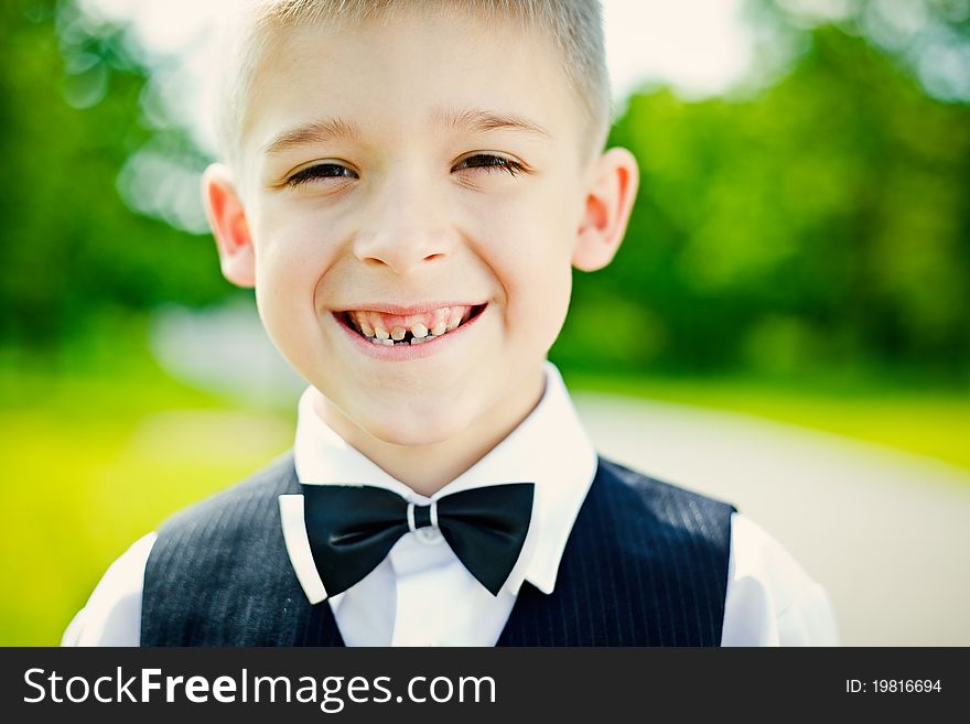 Little boy in a shirt and vest in park