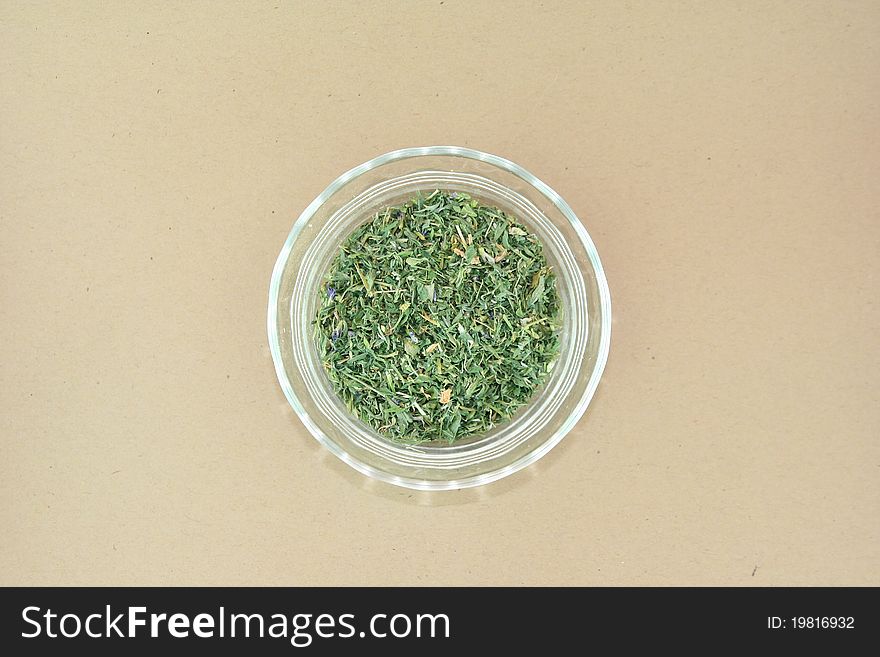 Dried alfalfa herbs in a glass bowl