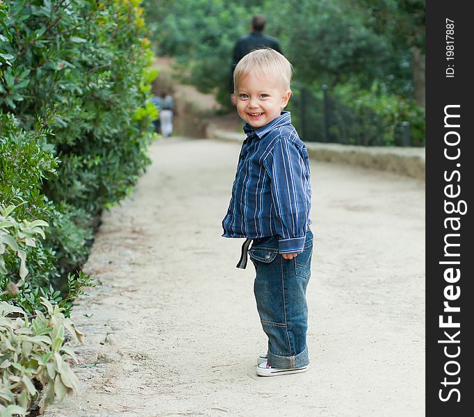 Cute 2 years old boy standing on the footpath in the park. Cute 2 years old boy standing on the footpath in the park