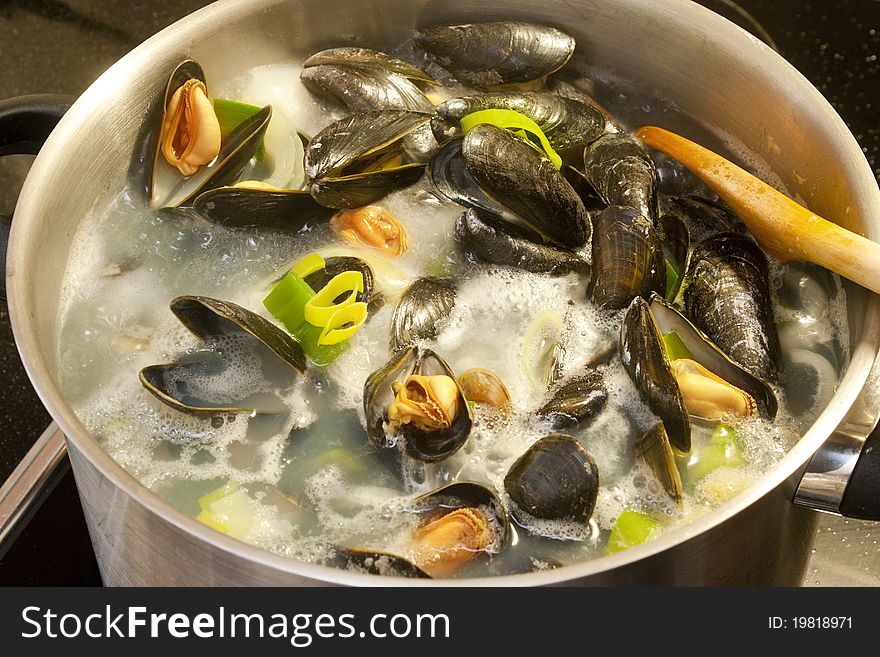 Mussels cooking in a big pan