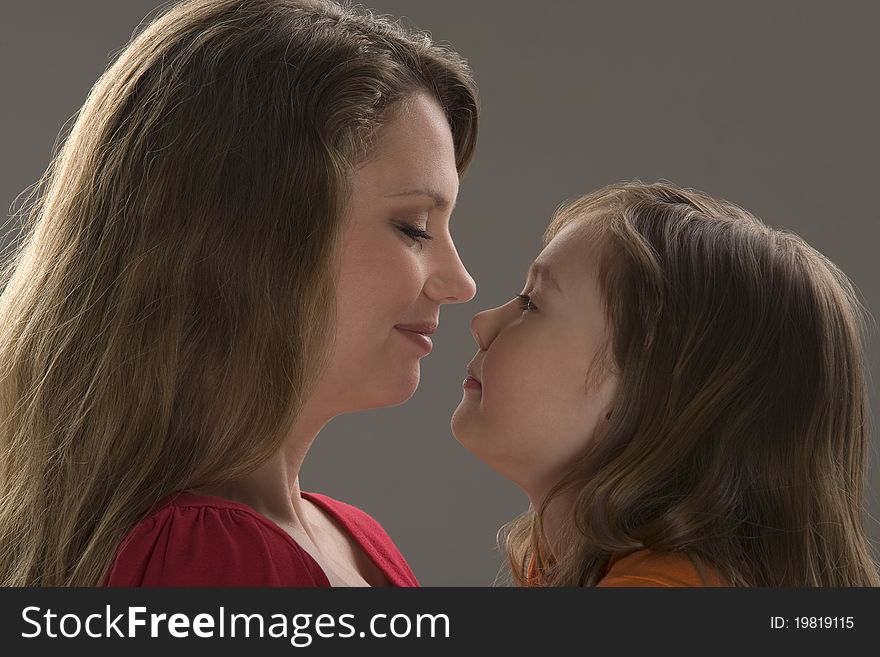 Mum and daughter sit at table and read book. Mum and daughter sit at table and read book