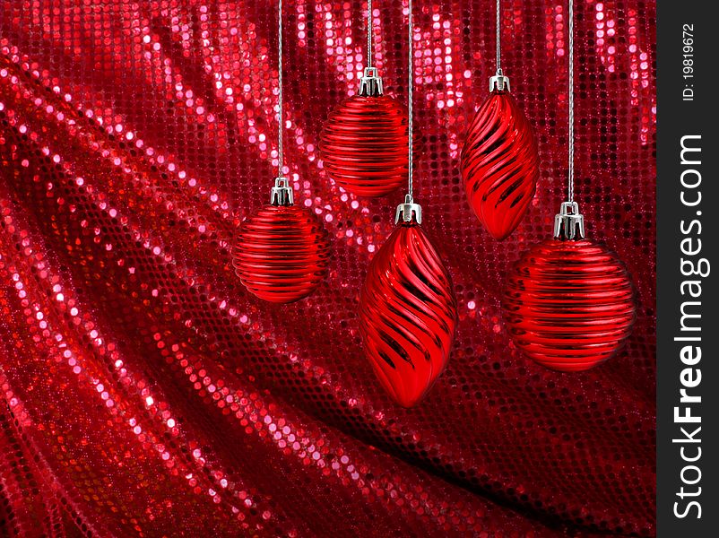 Red Christmas decoration balls and cones hanging on glitter canvas background