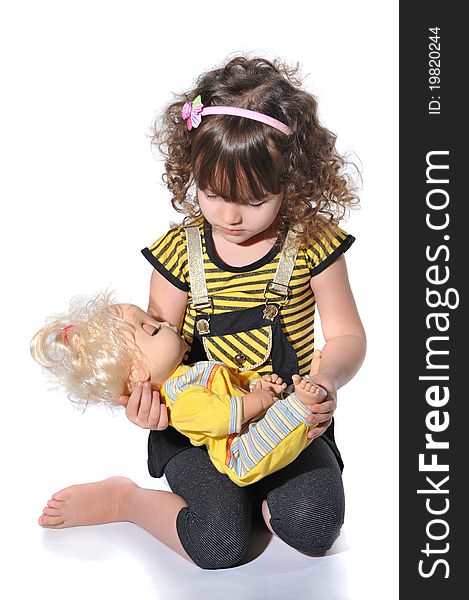 Portrait of sweet little girl playing with the doll in studio on white background. Portrait of sweet little girl playing with the doll in studio on white background