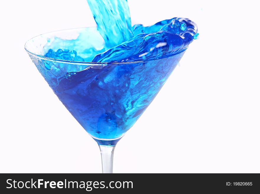 Blue liquid pouring into martini glass. Blue liquid pouring into martini glass