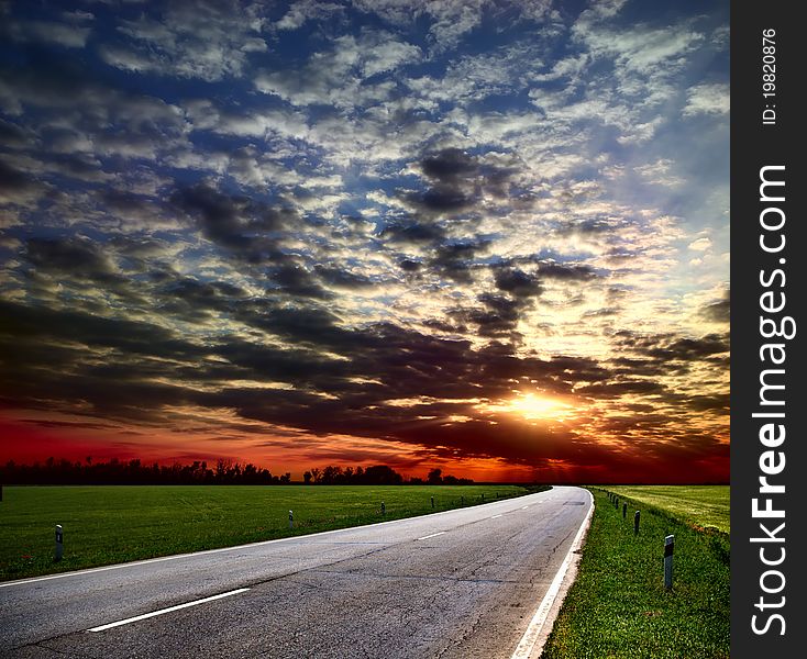 Country road among fields on the skyline