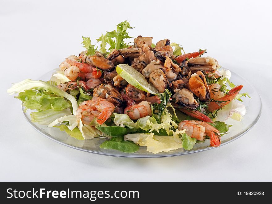A photo of salad with seafood and lettuce on a glass plate. A photo of salad with seafood and lettuce on a glass plate.