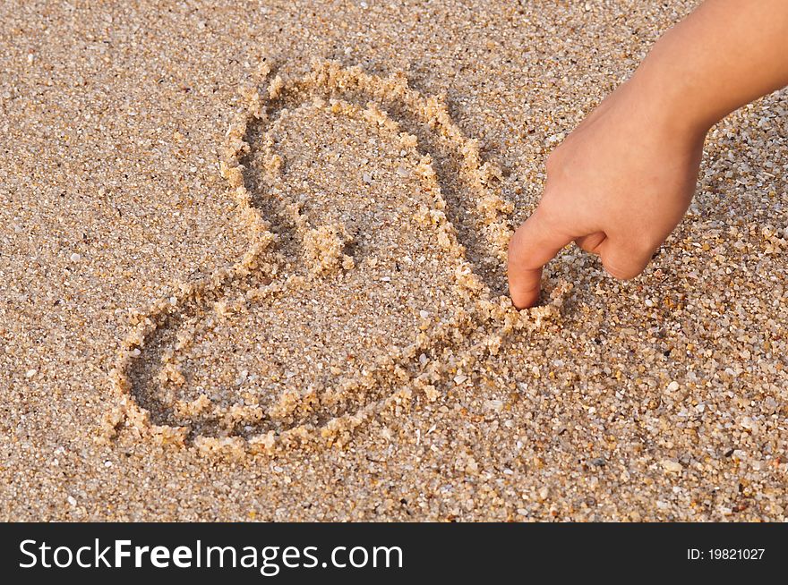 Writing heart on beach