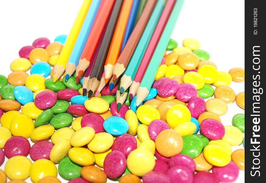 Crayons and smarties on a background