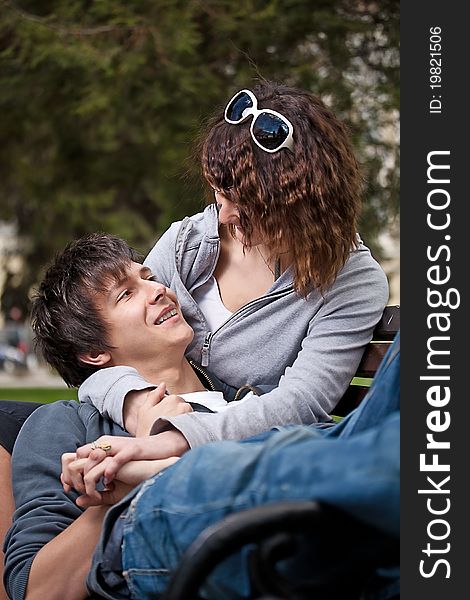 Attractive couple sitting on bench in the park