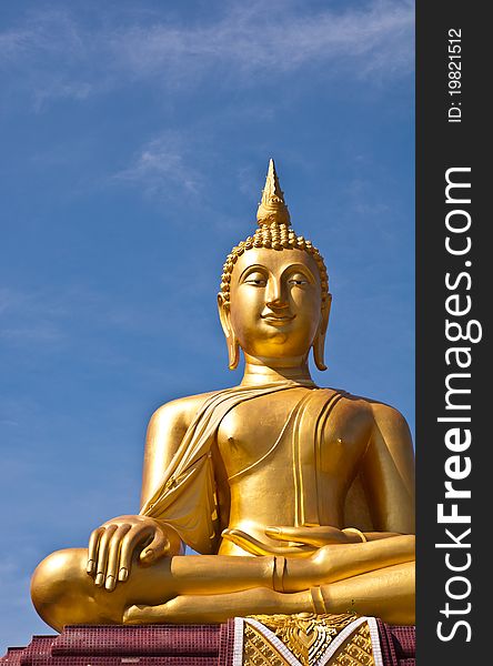 Golden buddha statue with blue sky background at thai temple