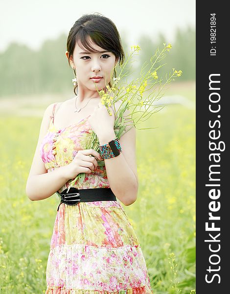 Asian summer girl holding a bunch of flowers in field. Asian summer girl holding a bunch of flowers in field.