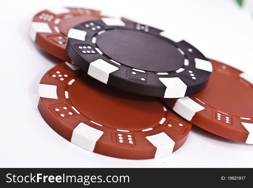 Red and black round poker chips on a white surface