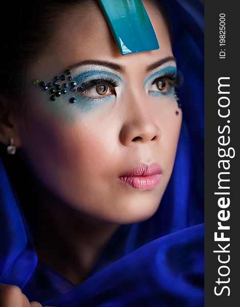 Young beautiful Asian woman in a blue veil posing with makeup