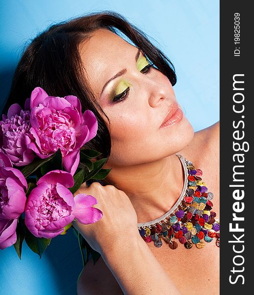 Porrait of beautiful young woman with art make up and flowers