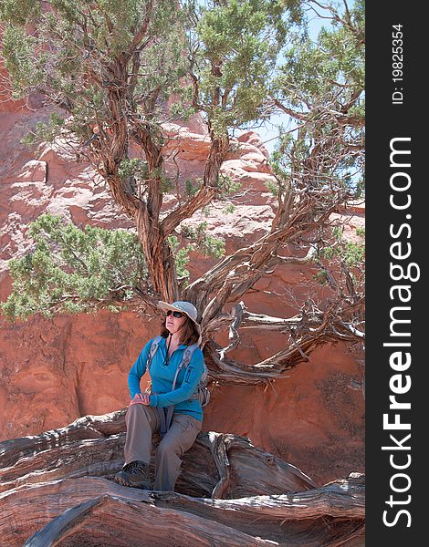 Woman hiker poses at a beautiful sandstone arch in Arches National Park. Woman hiker poses at a beautiful sandstone arch in Arches National Park