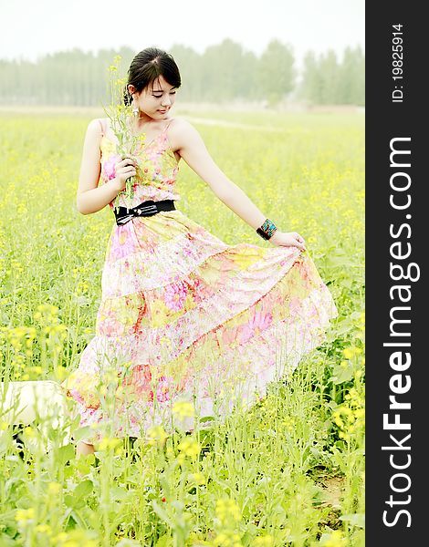 Chinese girl holding a bunch of rape flowers in rape field. Chinese girl holding a bunch of rape flowers in rape field.