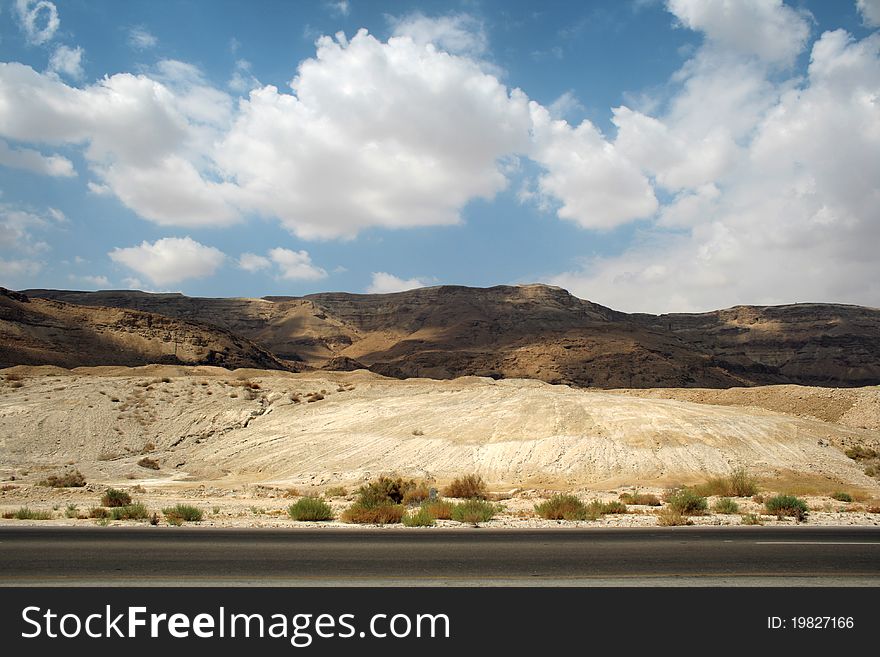 Stone desert and mountains along the road against the sky with clouds, Israel, Dead Sea area