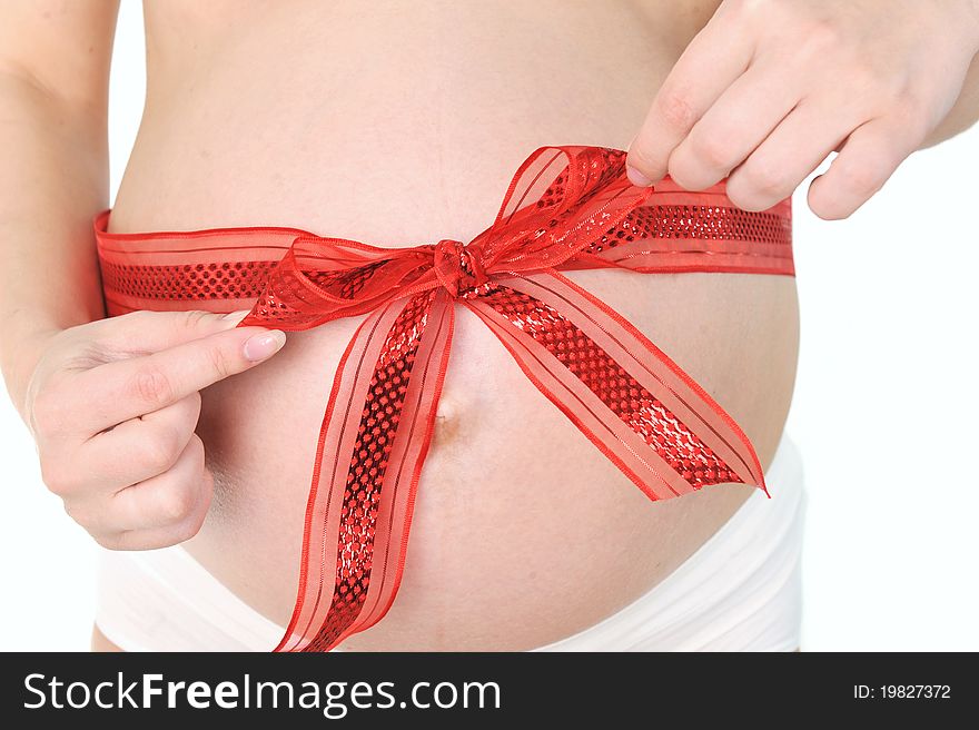 Hands of woman tied red ribbon around her pregnant belly. Hands of woman tied red ribbon around her pregnant belly