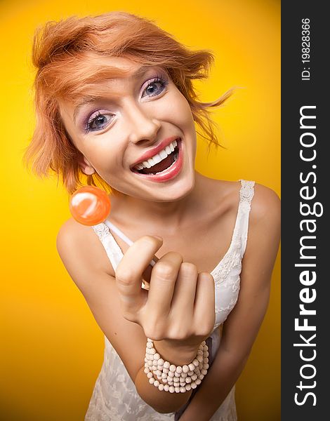 Smiling cute woman showing lollipop