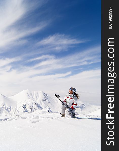 Beautiful skier on the top of mountain Ejder looking at the sky