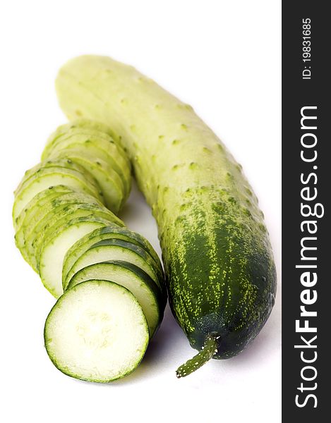 One whole and one sliced cucumber on white background. One whole and one sliced cucumber on white background