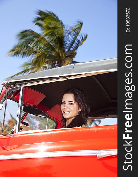 Beautiful young woman driving old car and smiling. Beautiful young woman driving old car and smiling