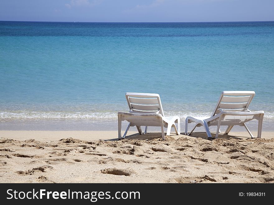 Two sunbeds on a tropical beach near the sea. Two sunbeds on a tropical beach near the sea