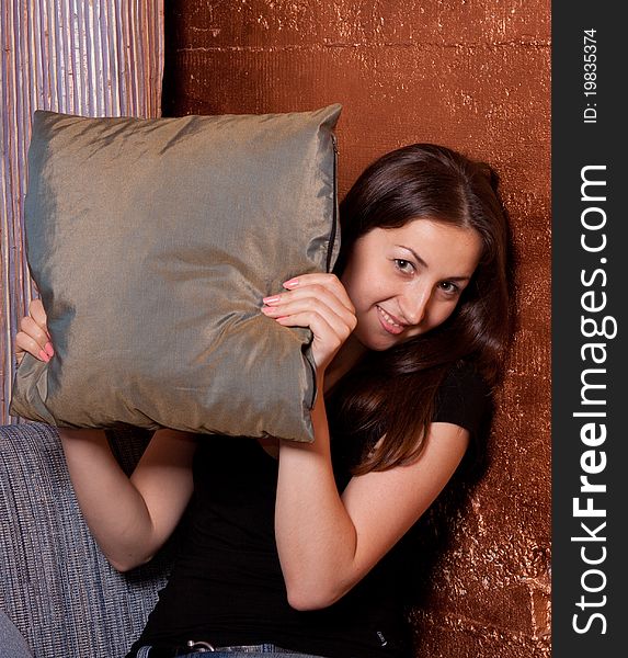 The girl looks out of pillows and coquettish smiles. The girl looks out of pillows and coquettish smiles