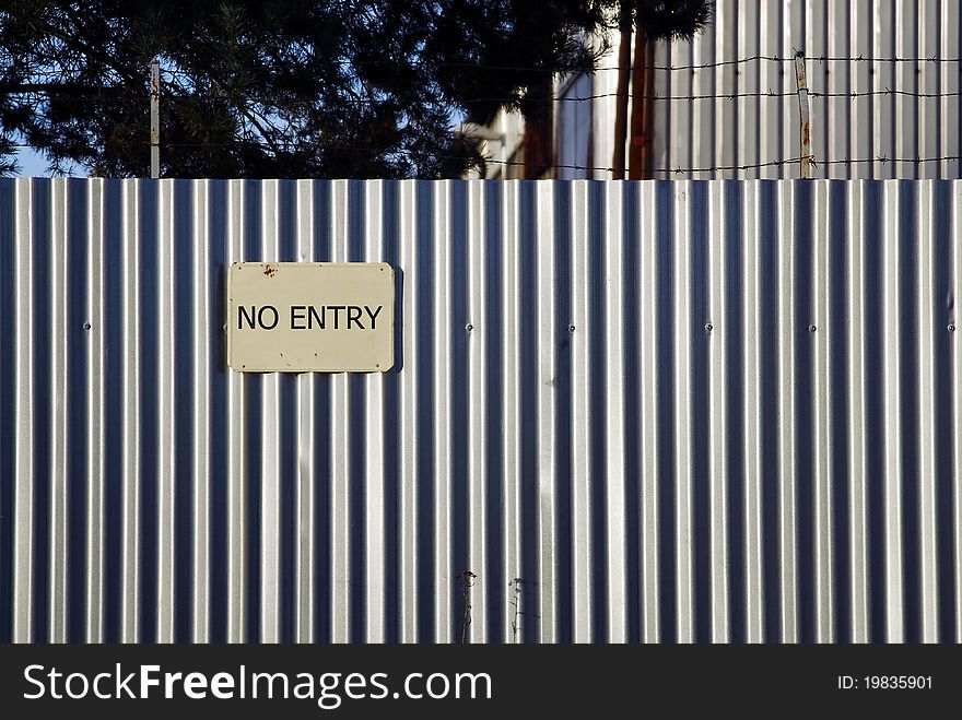 Barbed wire on the metal wall with with no entry