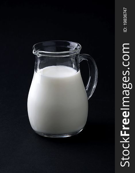 Jugful of milk isolated on black background