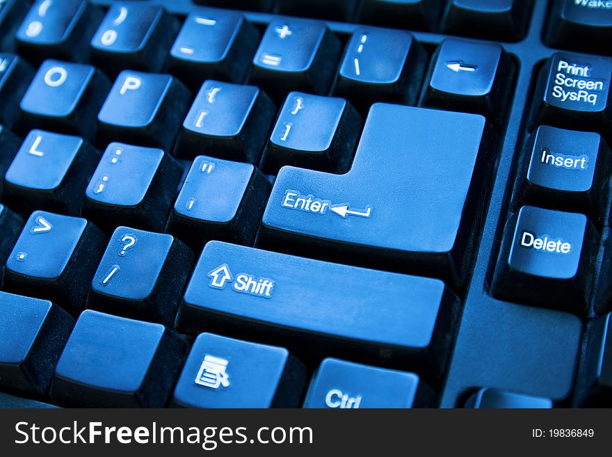 Close-up of computer keyboard. Toned in blue