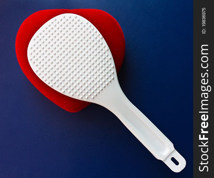 White plastic Scoop is placed on a heart shape. White plastic Scoop is placed on a heart shape.