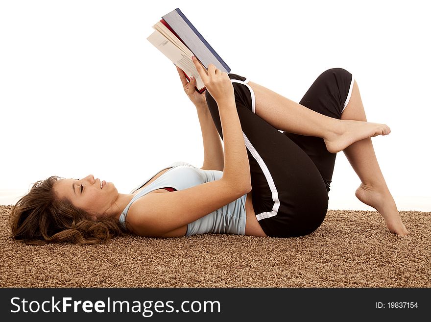 A female laying down and relaxing and reading a book. A female laying down and relaxing and reading a book.