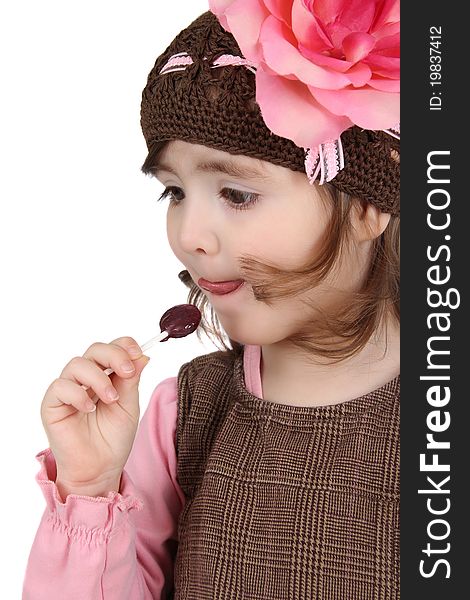 Cute brunette toddler earing a lollipop against white background. Cute brunette toddler earing a lollipop against white background