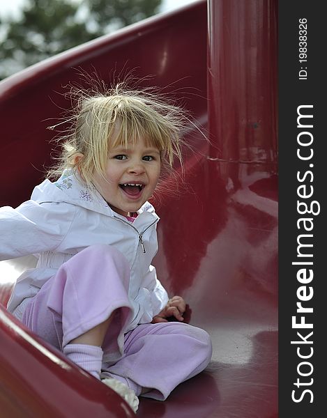 Happpy and Smiling Young Girl on Slide. Happpy and Smiling Young Girl on Slide