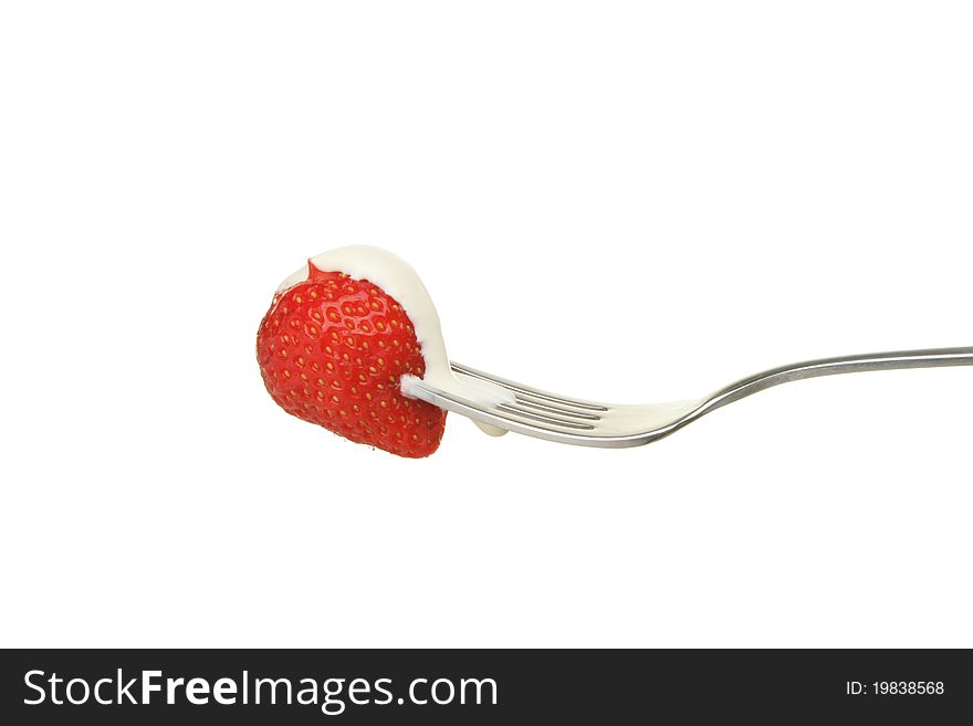 Strawberry with cream on a fork isolated against white