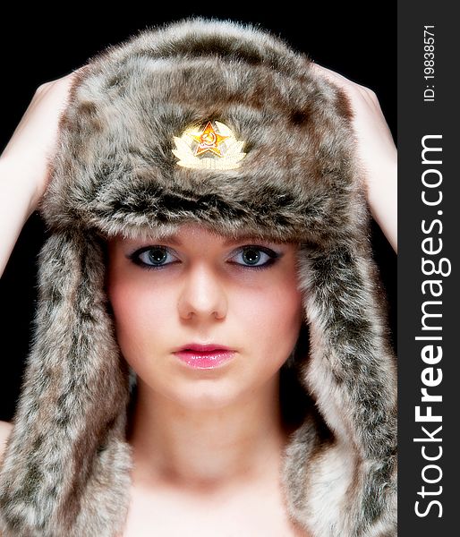 Image showing pretty young blonde female isolated against black with fur hat. Image showing pretty young blonde female isolated against black with fur hat