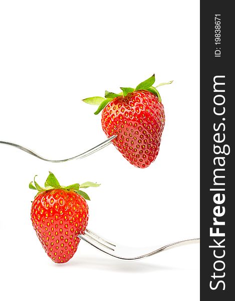 Strawberries on forks isolated on white background