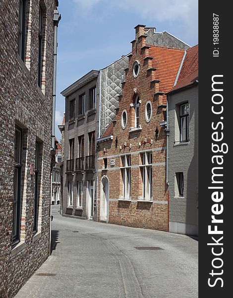 The example of narrow street consisting of modern buildings in Bruges, Belgium. The example of narrow street consisting of modern buildings in Bruges, Belgium.